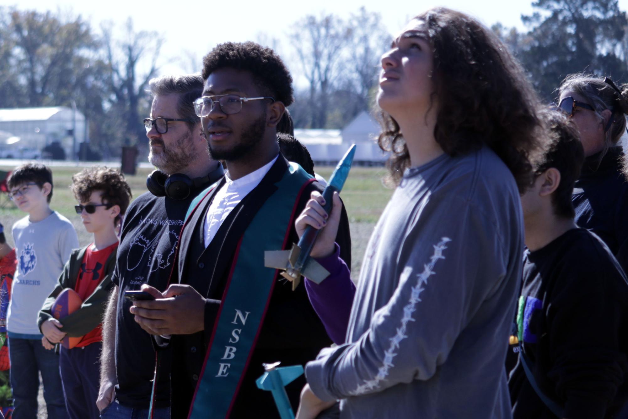 The Trojans Takeoff Team looks to the sky above Randolph Farm as they practice for the final launch which will take place in April 2024 in Alabama. Photo by Rashai Enoch Bailey.