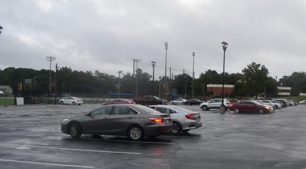 Students park in the Rogers Stadium parking lot during a rainy day. Students will need to purchase a parking pass and display the decal beginning on Oct. 1, 2024. Photo by Helaina Ballou. 