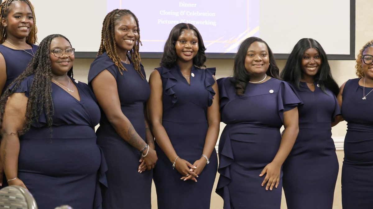 Newly inducted members of EmpowerHer stand together for one of their first group photos during the ceremony and dinner at Gateway. (Below) Board member Cassandra Price speaks at the podium about how she has been excited to be invited to work with this group of strong women. Photos by Helania Ballou.