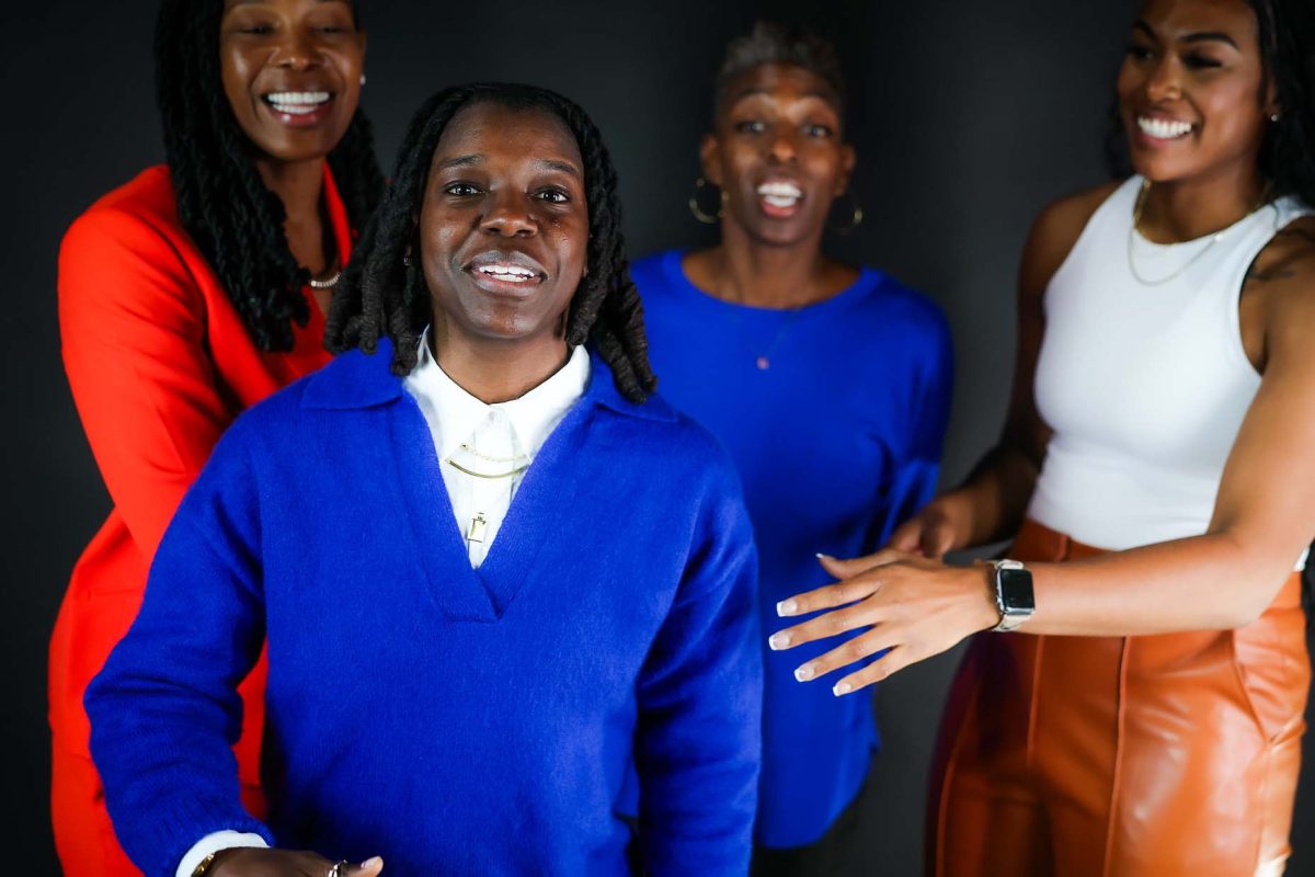Coach Kiera Howard steps forward as her head coach and other assistants joke with her.