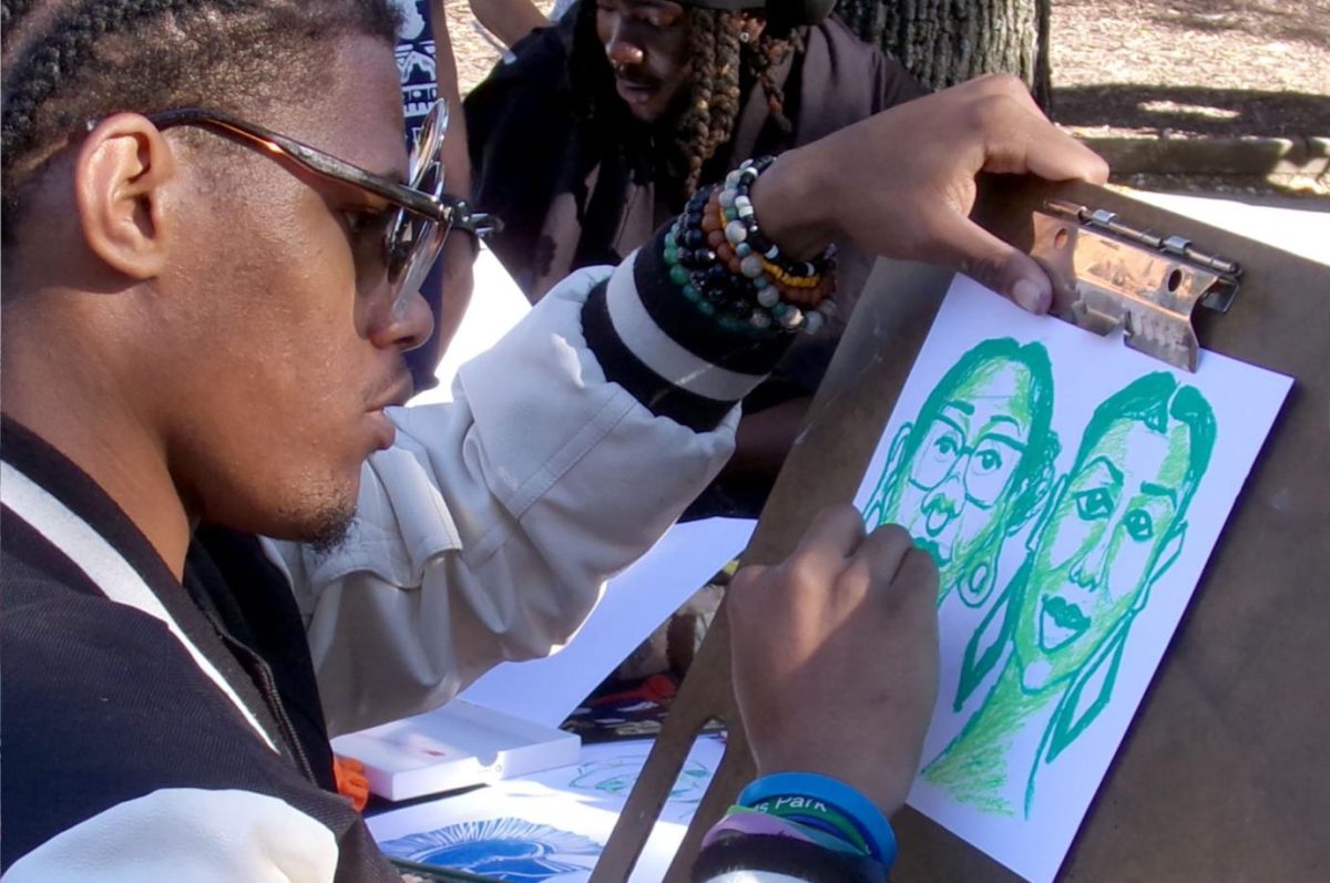 Joshua Branch-Howell draws portraits on campus during an event. Branch-Howell is one of the many artists involved in the Art + Design Student Org. Contributed photo.